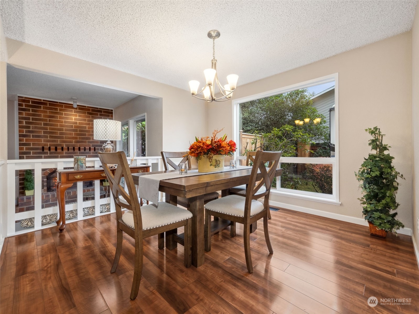 14130 148th Place Southeast Renton, WA 98059 - Photo 10 of 39 a dining room with wooden floor a chandelier a wooden table and chairs