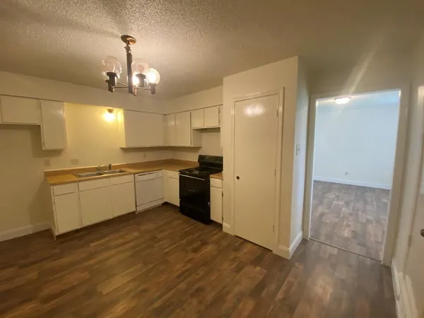 a view of a kitchen with a sink and wooden floor