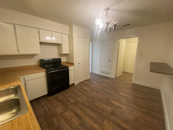 a kitchen that has a lot of cabinets and appliances