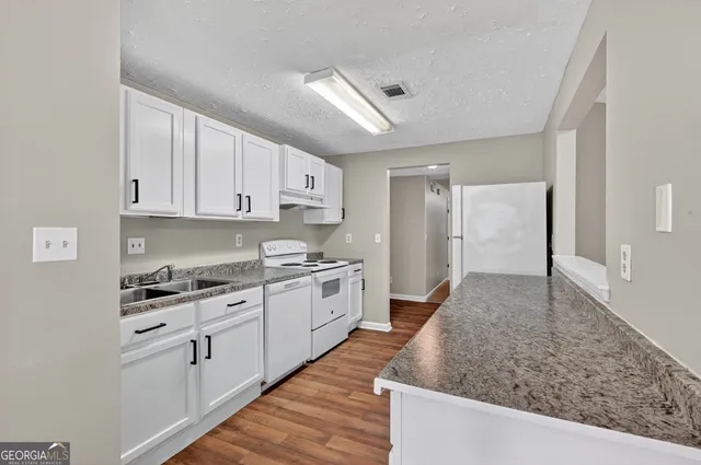 a kitchen with cabinets and wooden floor