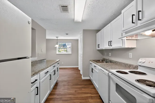 a large kitchen with cabinets and wooden floor