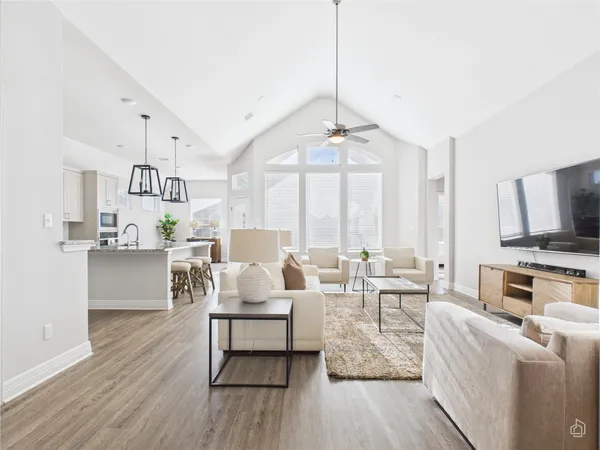 a living room with furniture flat screen tv and kitchen view
