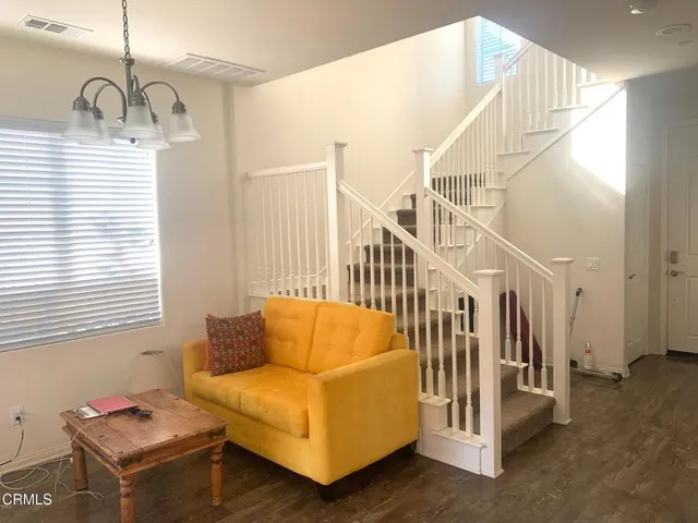 a living room with couches chairs and closet with wooden floor