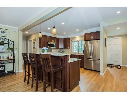 52 Harland Road Waltham, MA 02453 - Photo 5 of 37 a kitchen with stainless steel appliances kitchen island granite countertop a refrigerator a stove a sink a dining table and chairs with wooden floor