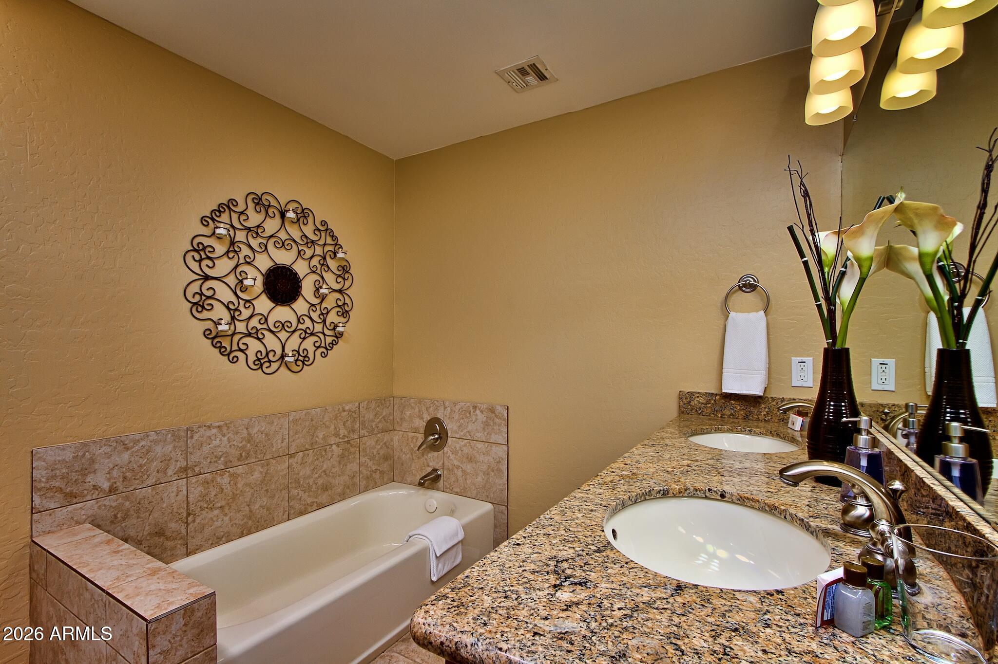 7609 East Indian Bend Road, Unit 3002 Scottsdale, AZ 85250 - Photo 12 of 19 a bathroom with a granite countertop sink and a mirror
