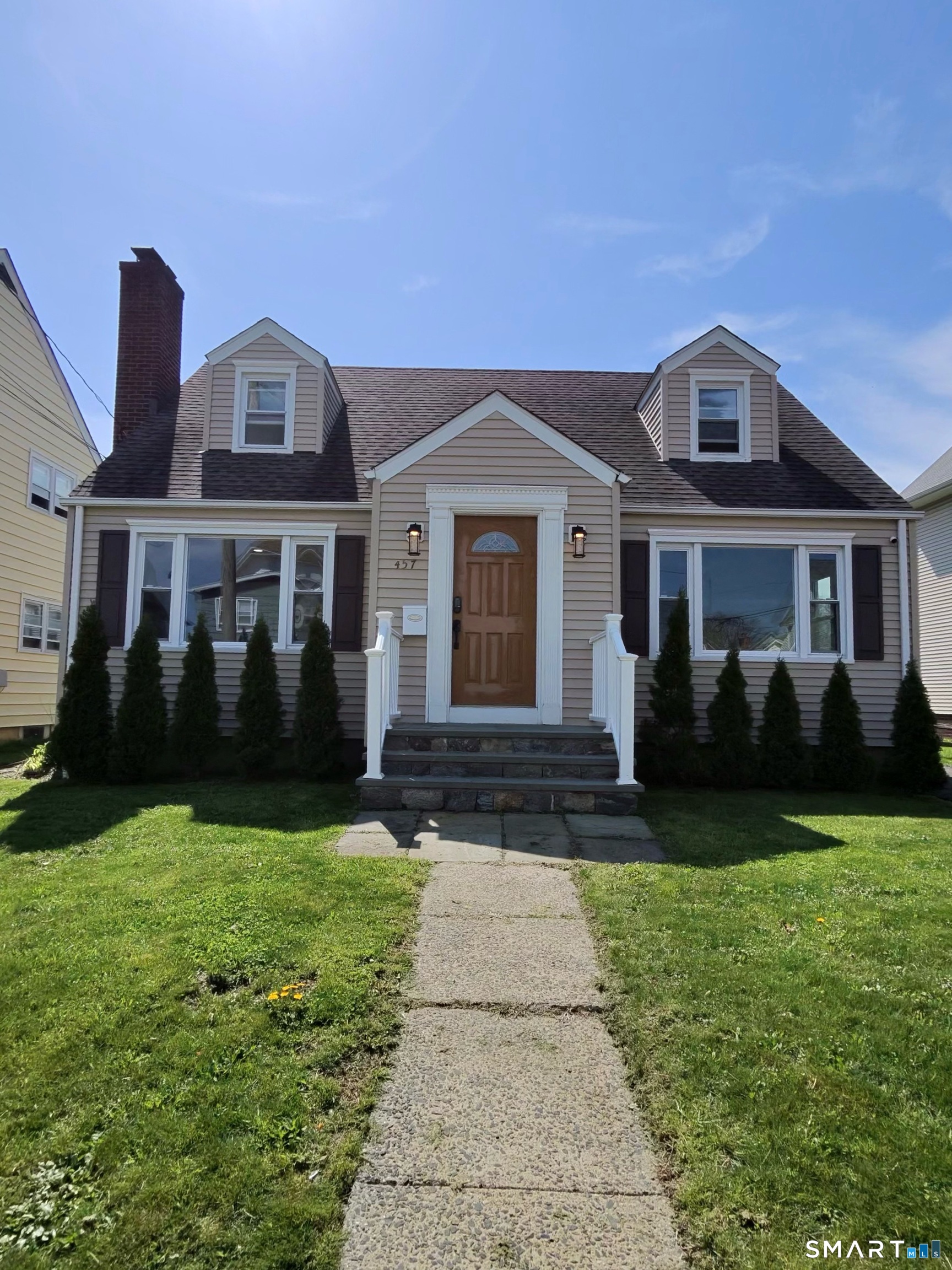 a front view of a house with yard and green space