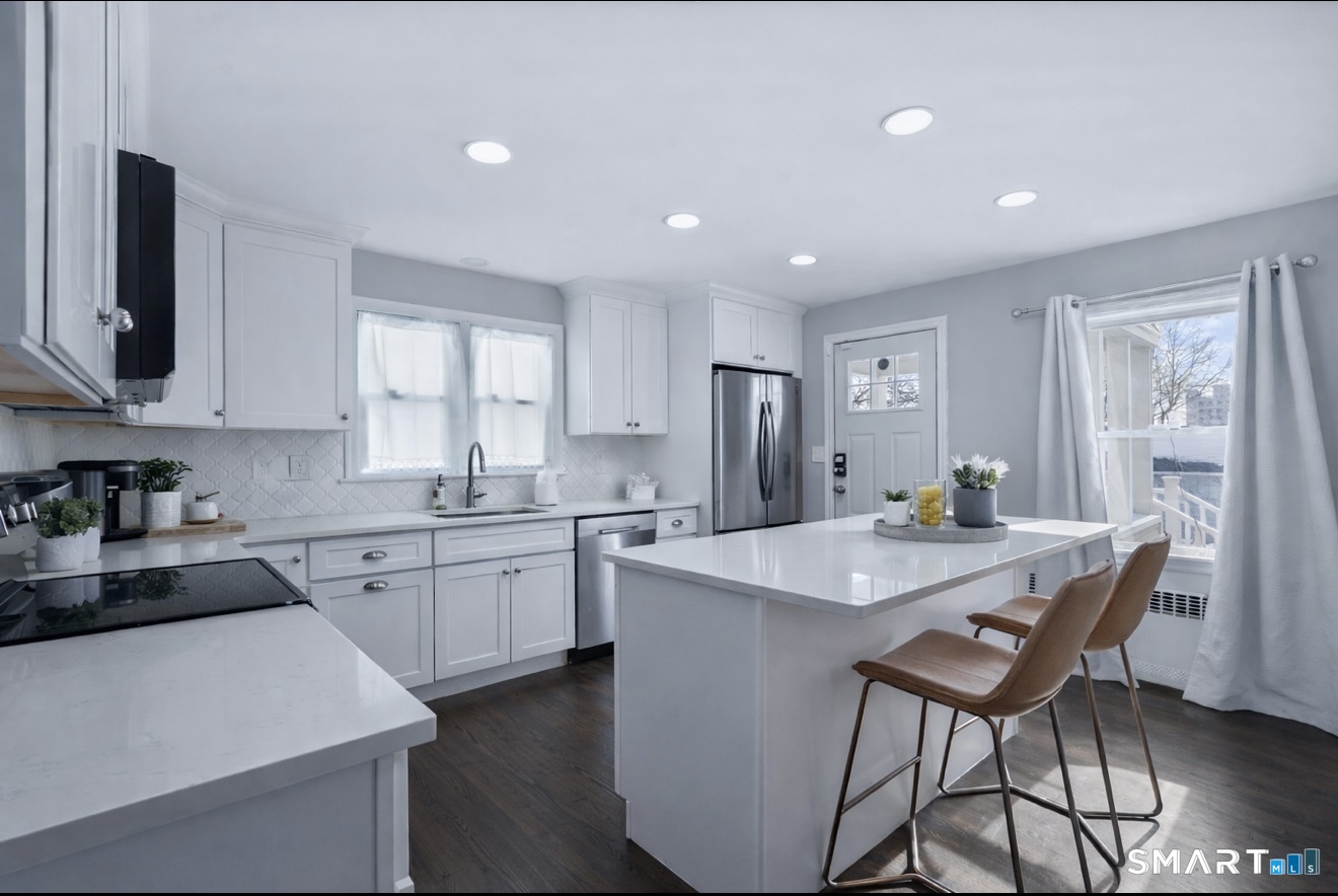 457 Summit Street Bridgeport, CT 06606 - Photo 3 of 9 a kitchen with stainless steel appliances granite countertop a stove a sink a refrigerator a microwave and white cabinets with wooden floor