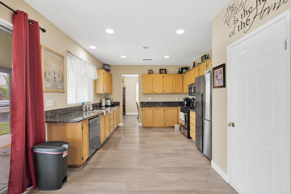 17866 Robusta Drive Riverside, CA 92503 - Photo 14 of 59 a kitchen with stainless steel appliances granite countertop a refrigerator a stove top oven a sink and dishwasher
