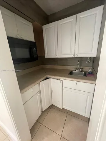 a kitchen with white cabinets and white appliances