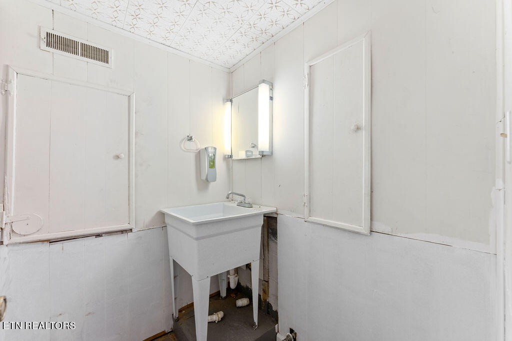 114 Tucker Road Oak Ridge, TN 37830 - Photo 14 of 22 a bathroom with a sink a mirror and a toilet