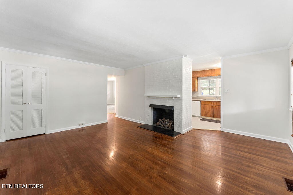 114 Tucker Road Oak Ridge, TN 37830 - Photo 3 of 22 a view of empty room with wooden floor and fireplace