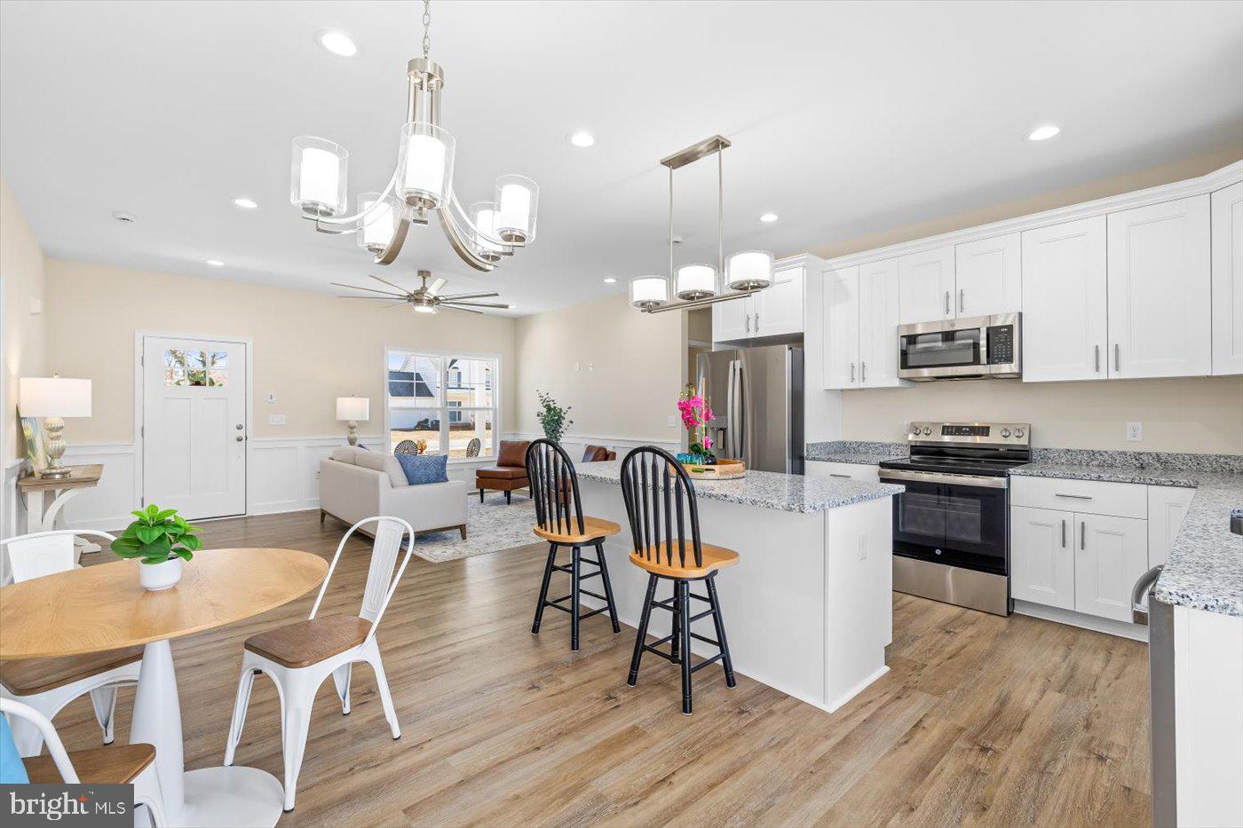 1419 South Glebe Road Montross, VA 22520 - Photo 36 of 76 a kitchen with stainless steel appliances a dining table a stove top oven a sink dishwasher and a dining table with wooden floor
