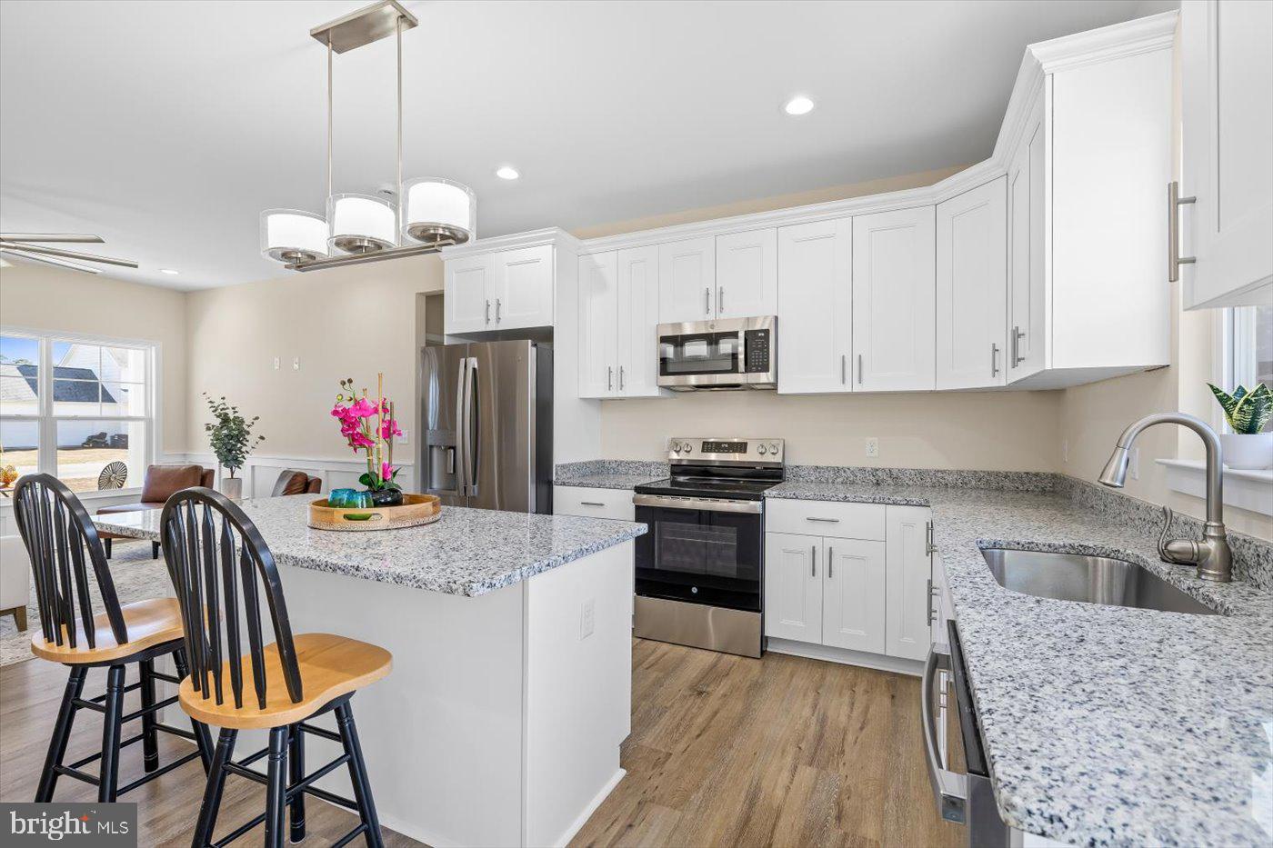 1419 South Glebe Road Montross, VA 22520 - Photo 37 of 76 a kitchen with stainless steel appliances granite countertop a refrigerator a stove a sink dishwasher a dining table and chairs with wooden floor