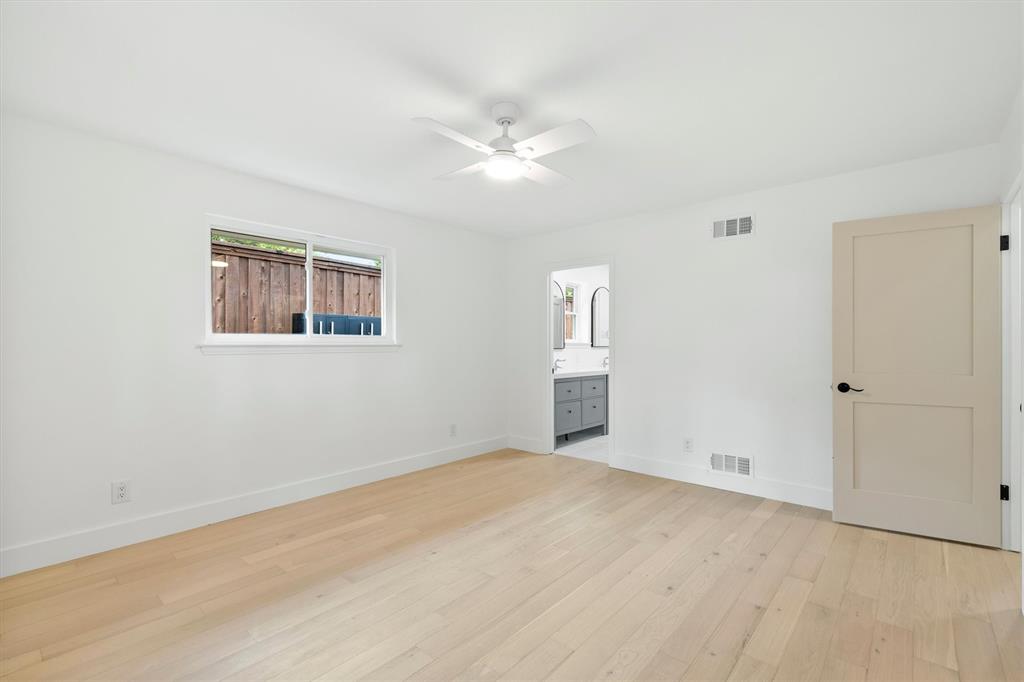 4446 Thunder Road Dallas, TX 75244 - Photo 16 of 30 Spacious room featuring light wood-finish flooring, a white ceiling fan, and ample natural light from a horizontal window