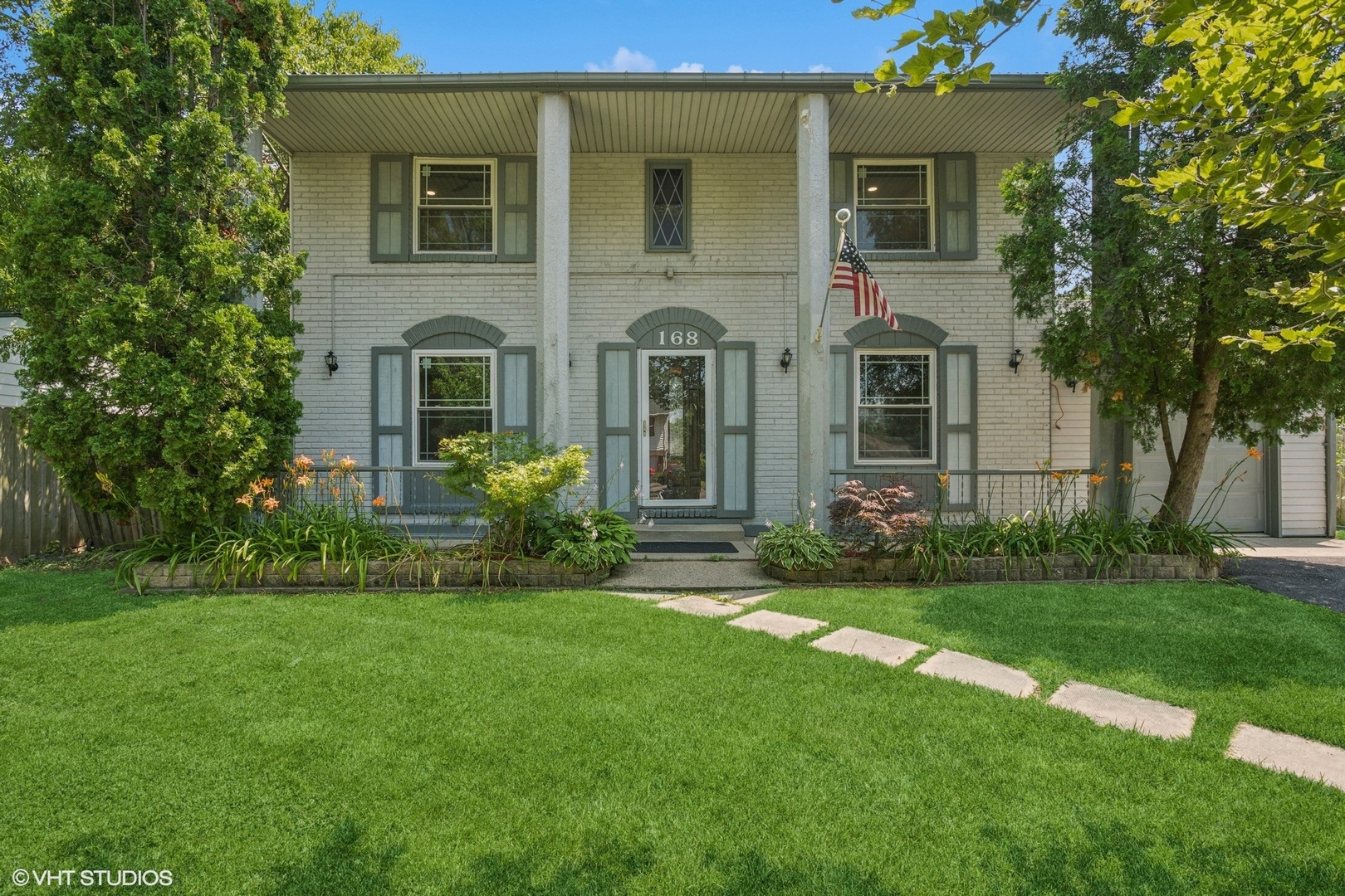 a front view of a house with a garden and yard