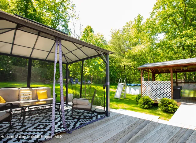 a view of a chair and tables in the patio with a backyard