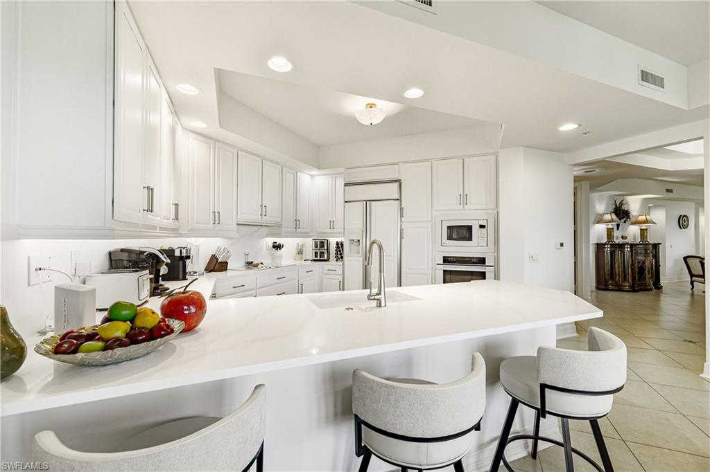 a kitchen with stainless steel appliances a sink a table and chairs