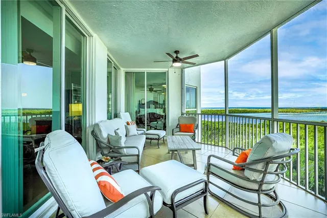 a living room with furniture and a floor to ceiling window