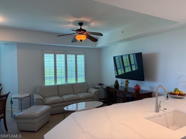 295 Grande Way, Unit 505 Naples, FL 34110 - Photo 4 of 20 Bedroom with tile patterned floors, ceiling fan, and a tray ceiling