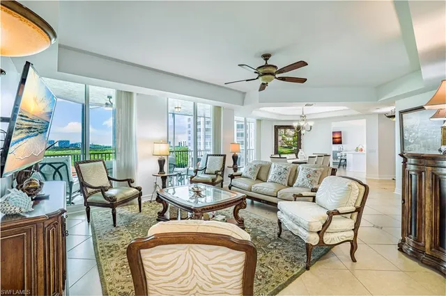 a living room with furniture a flat screen tv and a large window
