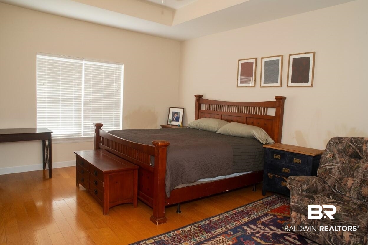 8008 Patricks Landing Road Bay Minette, AL 36507 - Photo 13 of 33 Bedroom featuring wood-finish flooring and a tray ceiling