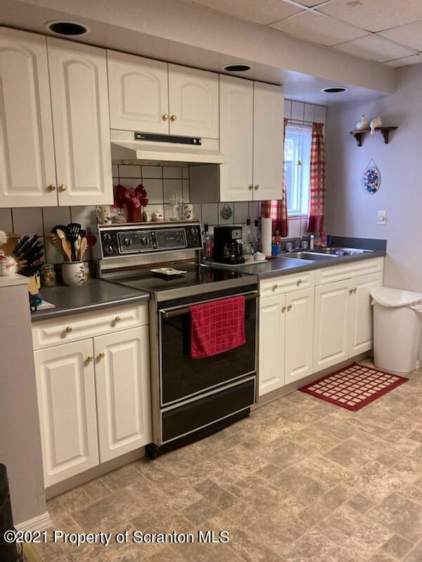 4 Prospect Street Simpson, PA 18407 - Photo 20 of 41 a kitchen with stainless steel appliances granite countertop a stove a sink and a white cabinets