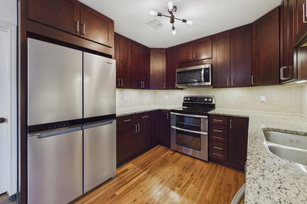 100 Colony Ridge Drive Alpharetta, GA 30022 - Photo 12 of 47 a kitchen with granite countertop wooden cabinets a refrigerator and a stove top oven