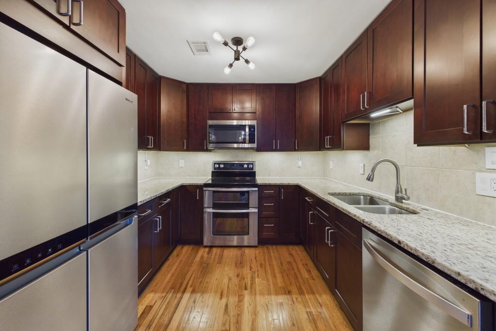 100 Colony Ridge Drive Alpharetta, GA 30022 - Photo 15 of 47 a kitchen with granite countertop wooden cabinets a stove top oven and refrigerator