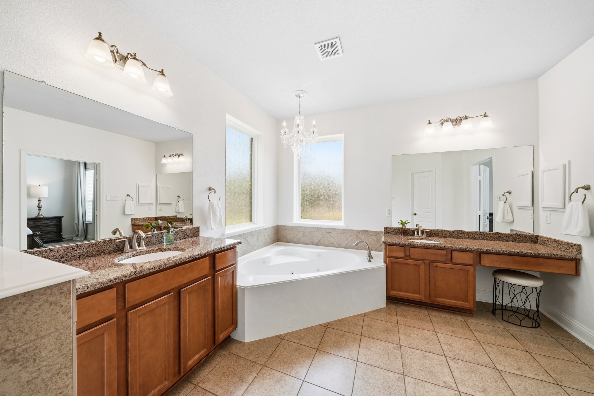 17610 Strackfield Lane Tomball, TX 77377 - Photo 25 of 50 A six-foot jetted tub serves as the centerpiece of the bathroom, perfectly positioned beneath dual rain-glass picture windows and illuminated by a sparkling chandelier, creating a spa-inspired retreat.