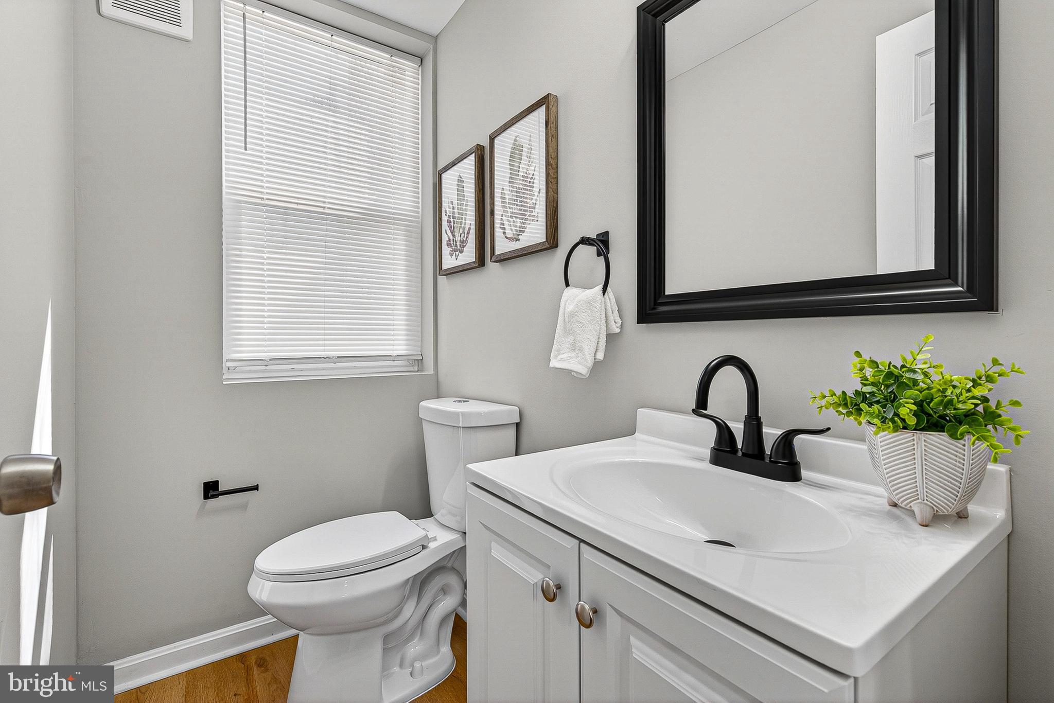 1725 East Oliver Street Baltimore, MD 21213 - Photo 11 of 30 a bathroom with a sink a mirror and a toilet