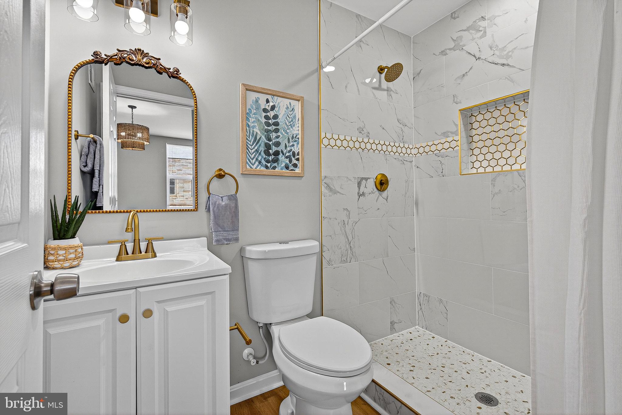 1725 East Oliver Street Baltimore, MD 21213 - Photo 16 of 30 a bathroom with a sink mirror vanity and toilet