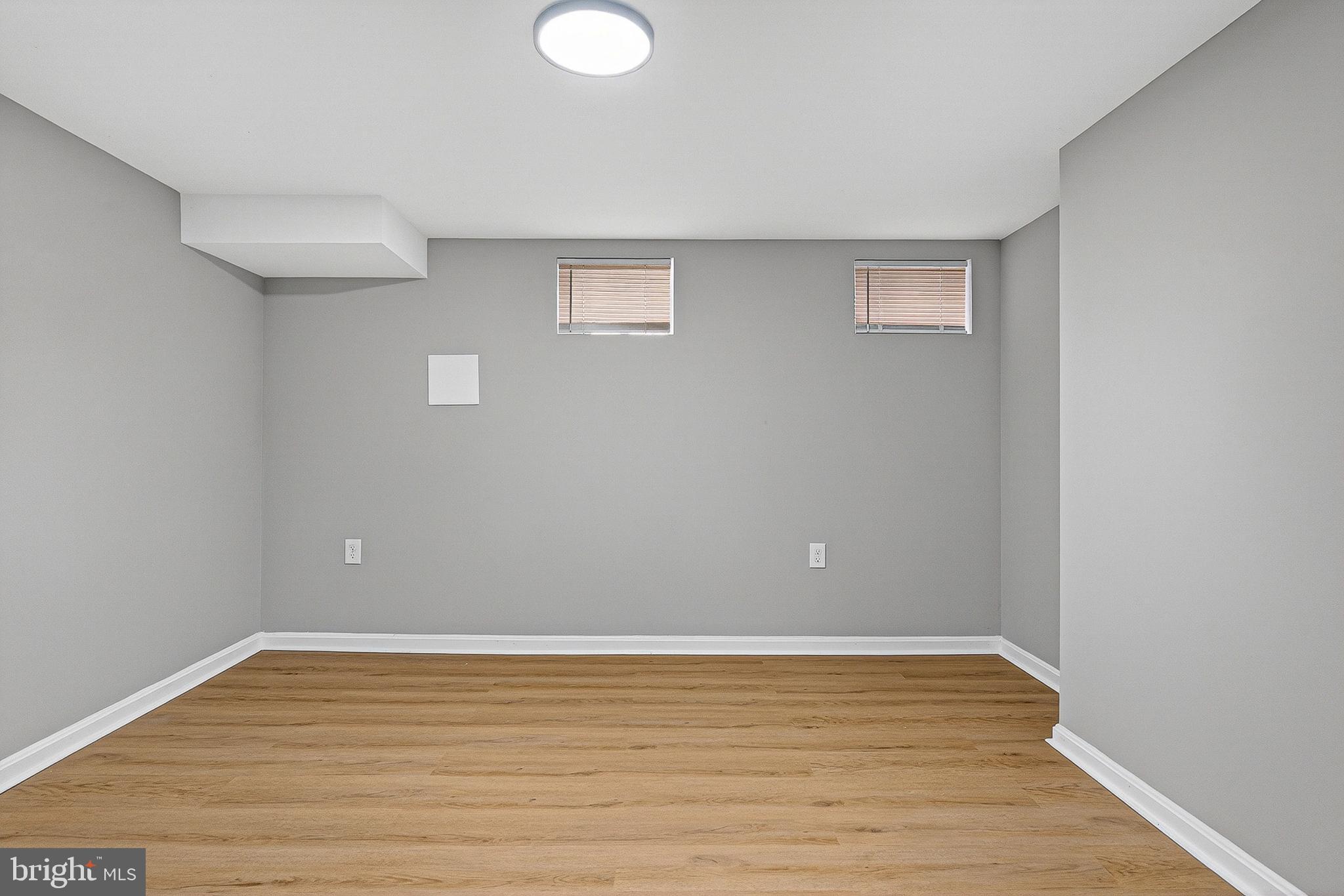 1725 East Oliver Street Baltimore, MD 21213 - Photo 19 of 30 a view of an empty room with wooden floor and a window