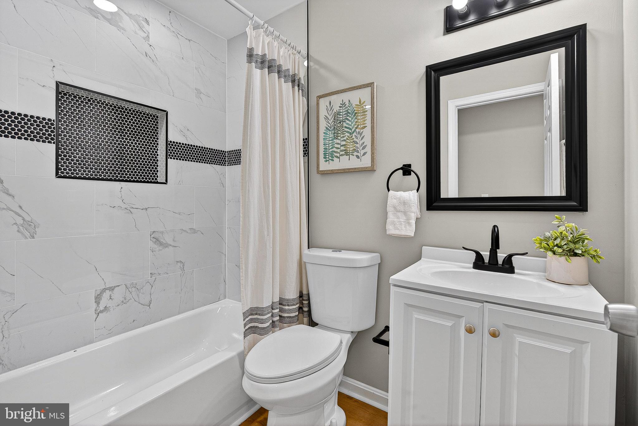 1725 East Oliver Street Baltimore, MD 21213 - Photo 20 of 30 a bathroom with a toilet sink vanity tub and mirror