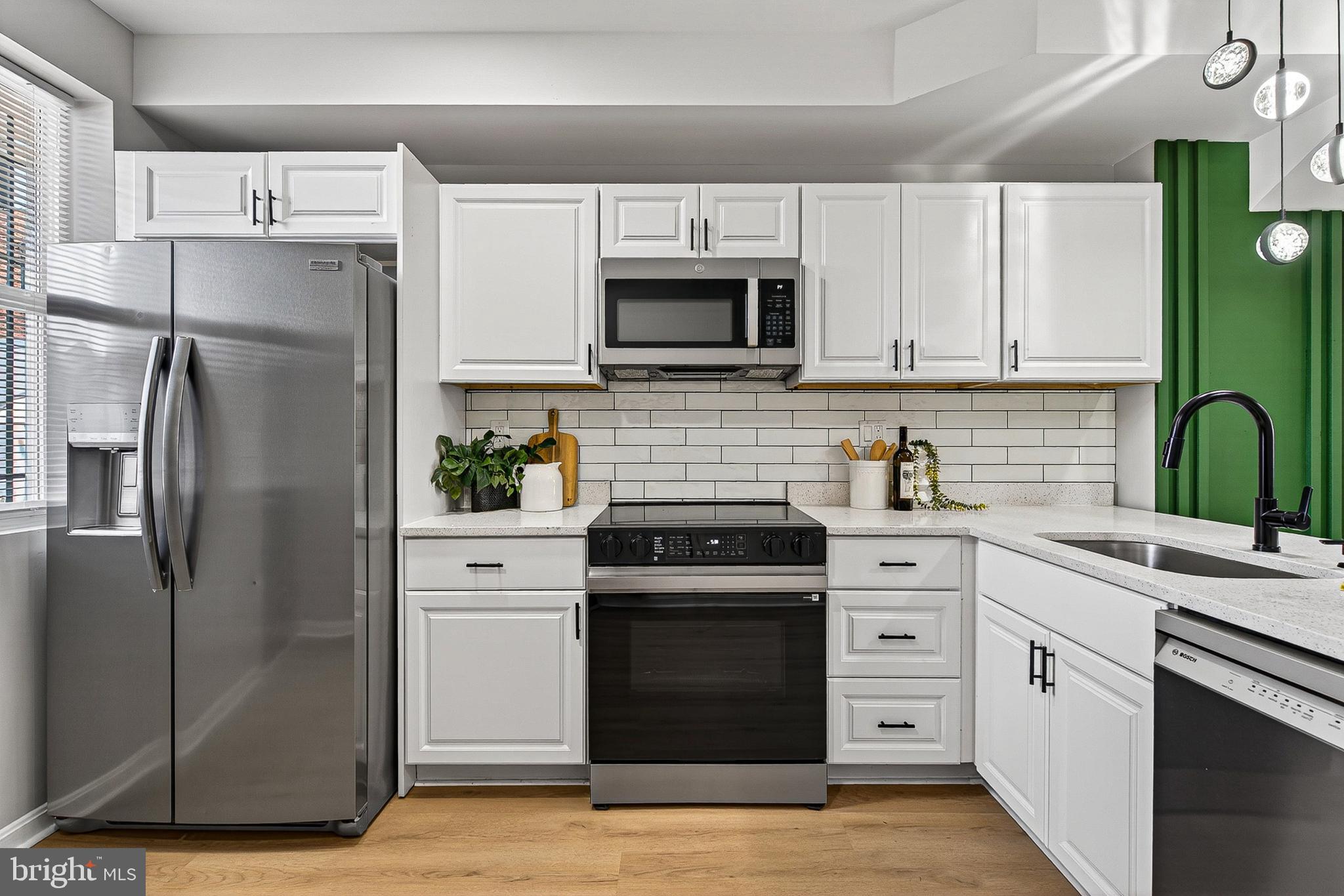 1725 East Oliver Street Baltimore, MD 21213 - Photo 2 of 30 a kitchen with stainless steel appliances cabinets and a counter top space