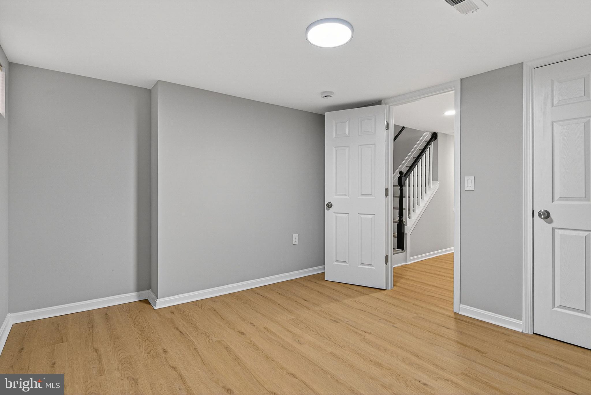 1725 East Oliver Street Baltimore, MD 21213 - Photo 21 of 30 an empty room with wooden floor and entrance