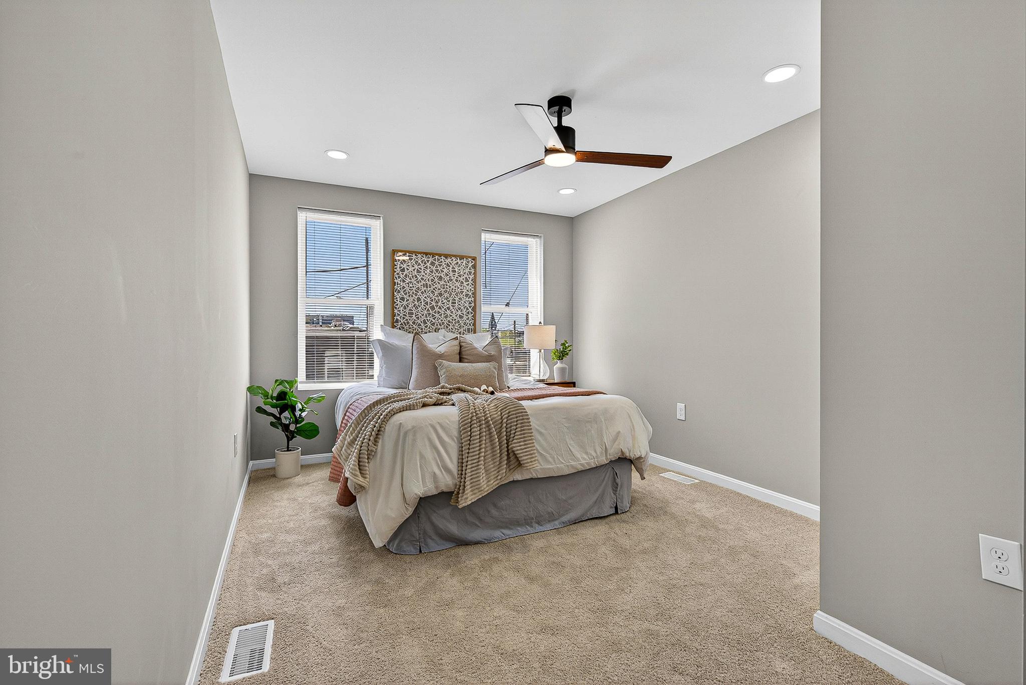 1725 East Oliver Street Baltimore, MD 21213 - Photo 22 of 30 a spacious bedroom with a bed and a chandelier