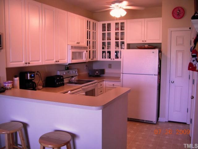 2110 Breezeway Drive, Unit 101 Raleigh, NC 27614 - Photo 3 of 12 Marvelous white kitchen 42' cabinets & glass displays, flat top stove built in micro, pantry & breakfast bar, large utility room for extra storage.