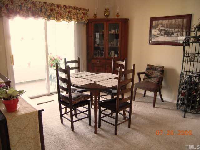 2110 Breezeway Drive, Unit 101 Raleigh, NC 27614 - Photo 4 of 12 Open dining room w/glass sliding door leading out to covered patio.
