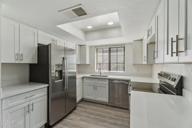 a kitchen with stainless steel appliances granite countertop a refrigerator and a sink