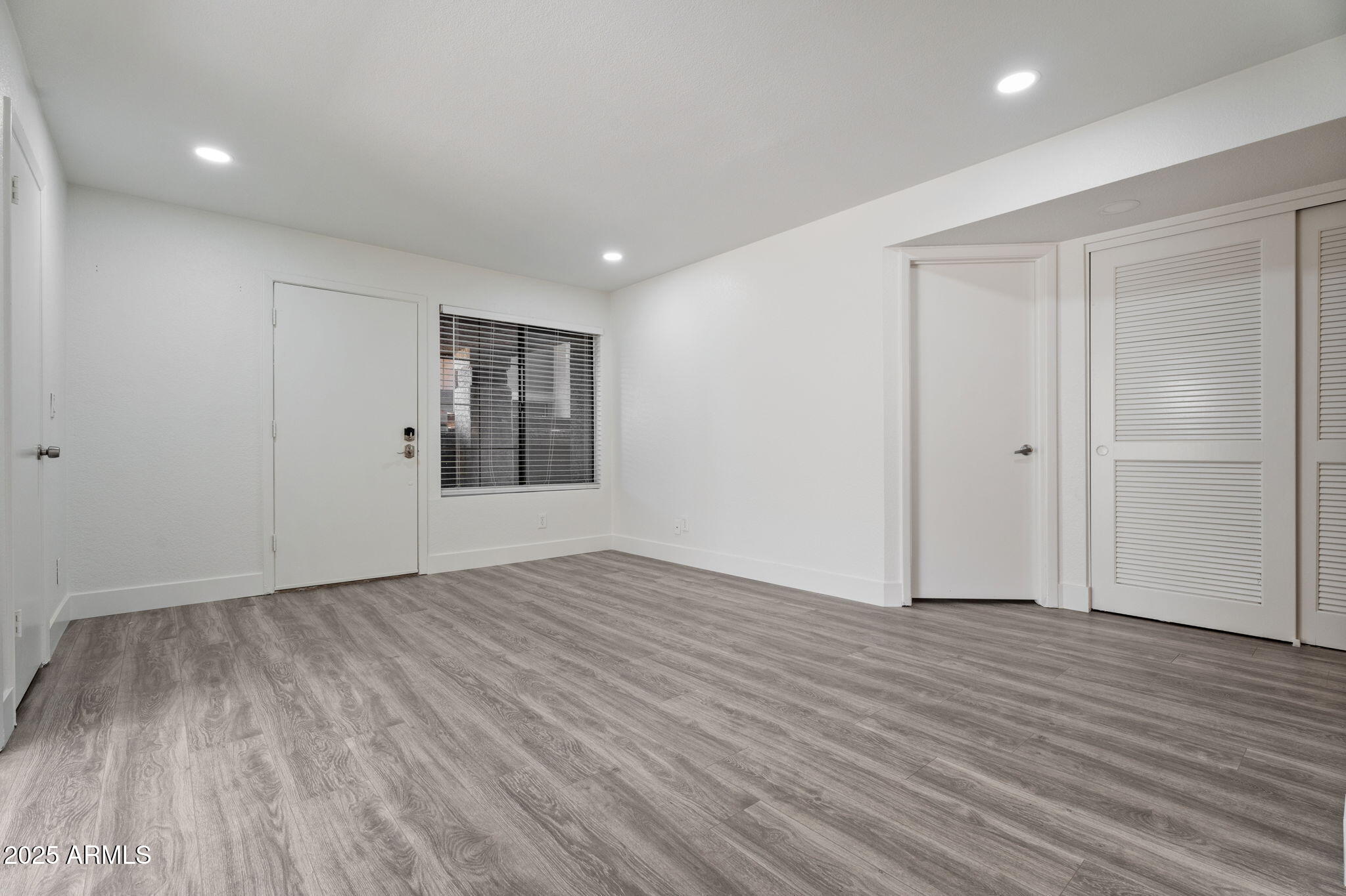 1905 East University Drive, Unit 133 Tempe, AZ 85288 - Photo 15 of 38 a view of an empty room with wooden floor and window