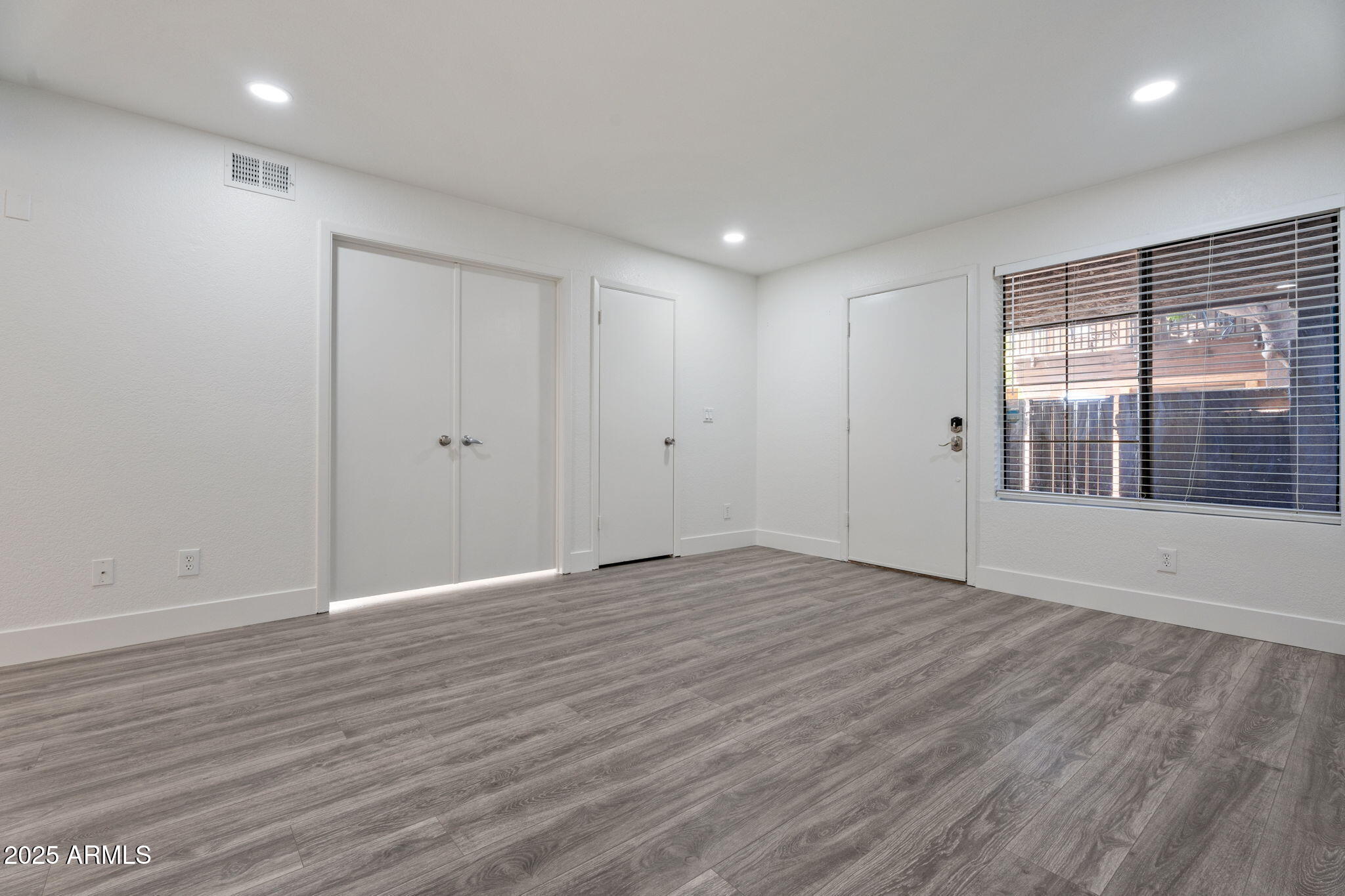 1905 East University Drive, Unit 133 Tempe, AZ 85288 - Photo 16 of 38 an empty room with wooden floor and windows