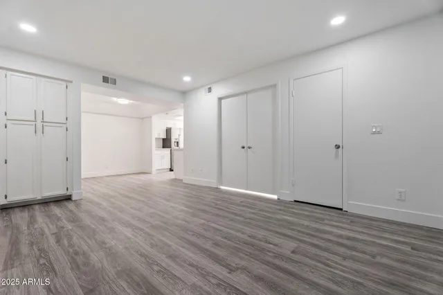 a view of empty room with wooden floor
