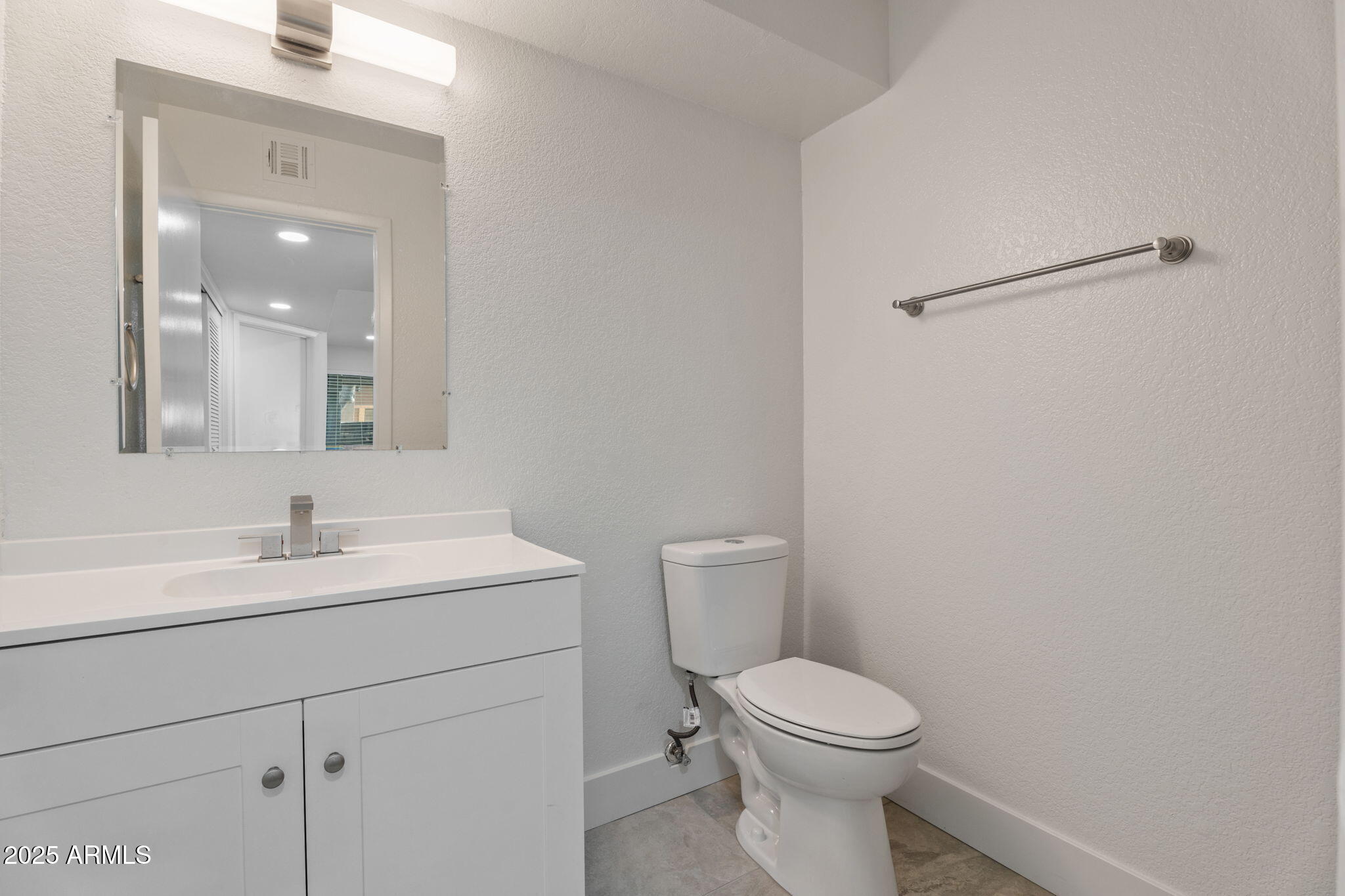 1905 East University Drive, Unit 133 Tempe, AZ 85288 - Photo 23 of 38 a bathroom with a toilet sink vanity and mirror