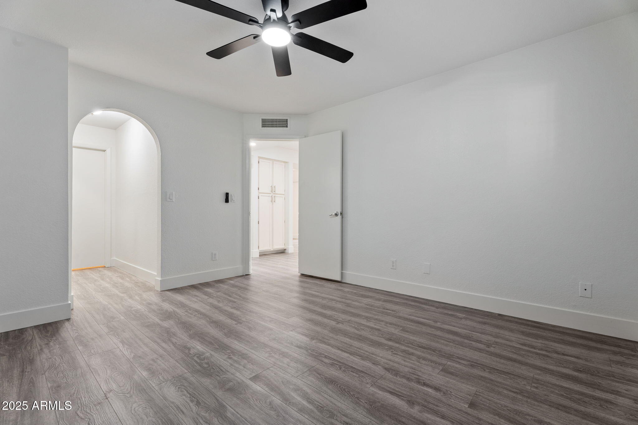 1905 East University Drive, Unit 133 Tempe, AZ 85288 - Photo 26 of 38 an empty room with wooden floor chandelier fan and closet area