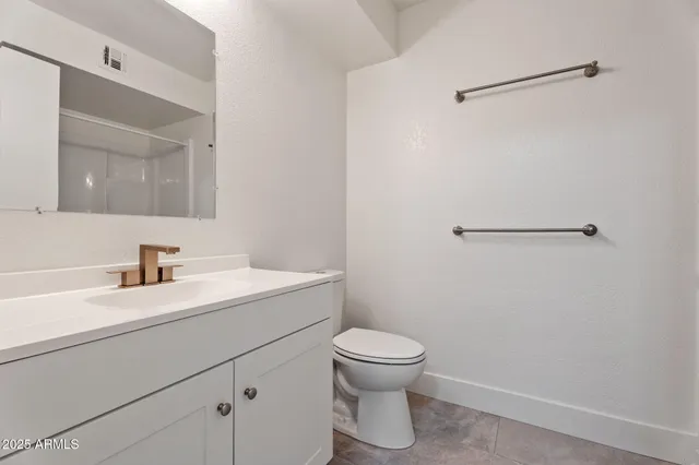 a bathroom with a sink a toilet and a mirror