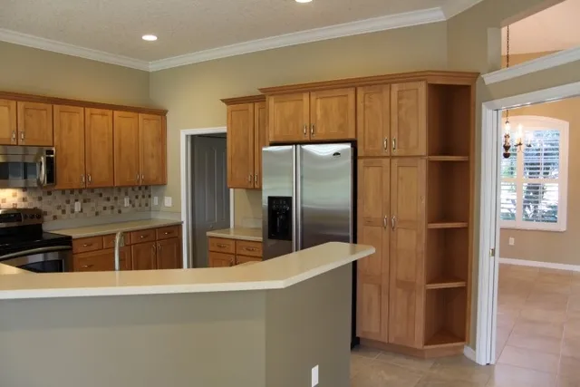 a kitchen with stainless steel appliances granite countertop a refrigerator and a stove top oven