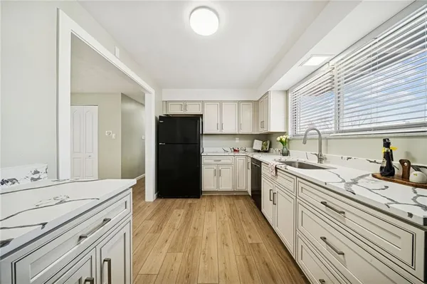 a kitchen with granite countertop a refrigerator stove top oven and sink
