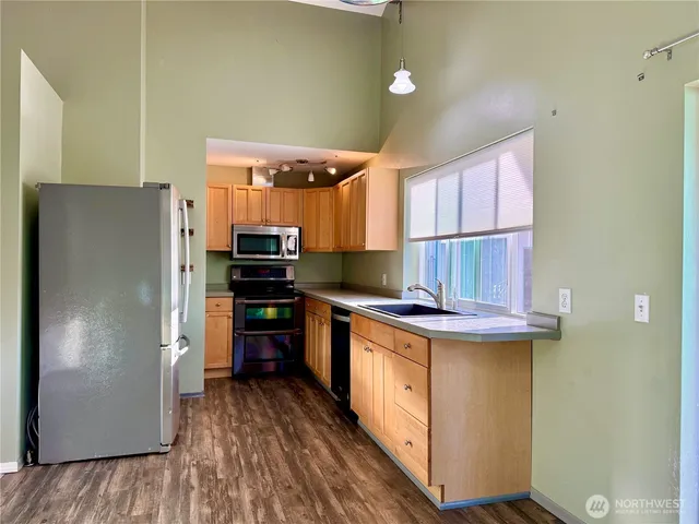 an empty room with windows and refrigerator