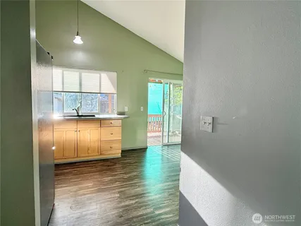 an empty room with windows and refrigerator
