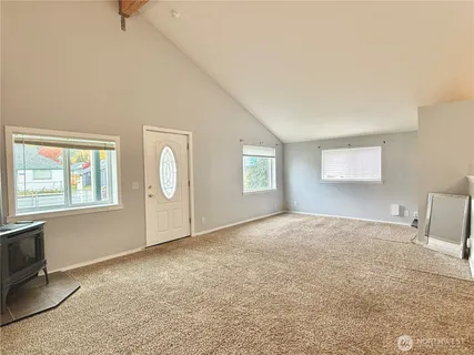 a view of an empty room with closet and a window